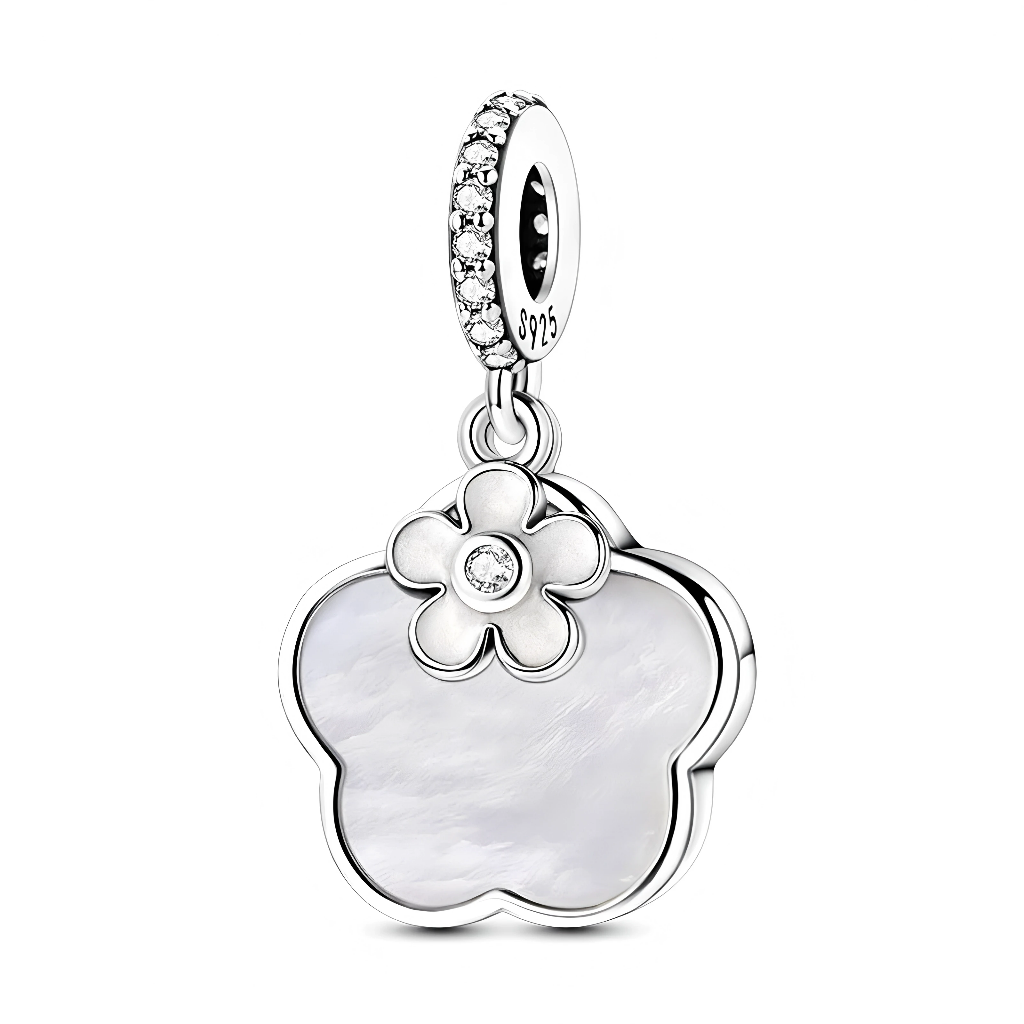 Ce charm pendentif en argent 925 met en valeur un grand motif trèfle à quatre feuilles serti d’une nacre blanche lumineuse, surmonté d’une petite fleur stylisée en métal poli. Le centre de la fleur est orné d’un zircon scintillant, tandis que l’anneau supérieur, pavé de petites pierres brillantes, apporte une touche d’éclat supplémentaire dans l’esprit des charms floraux en nacre très prisés en joaillerie contemporaine.