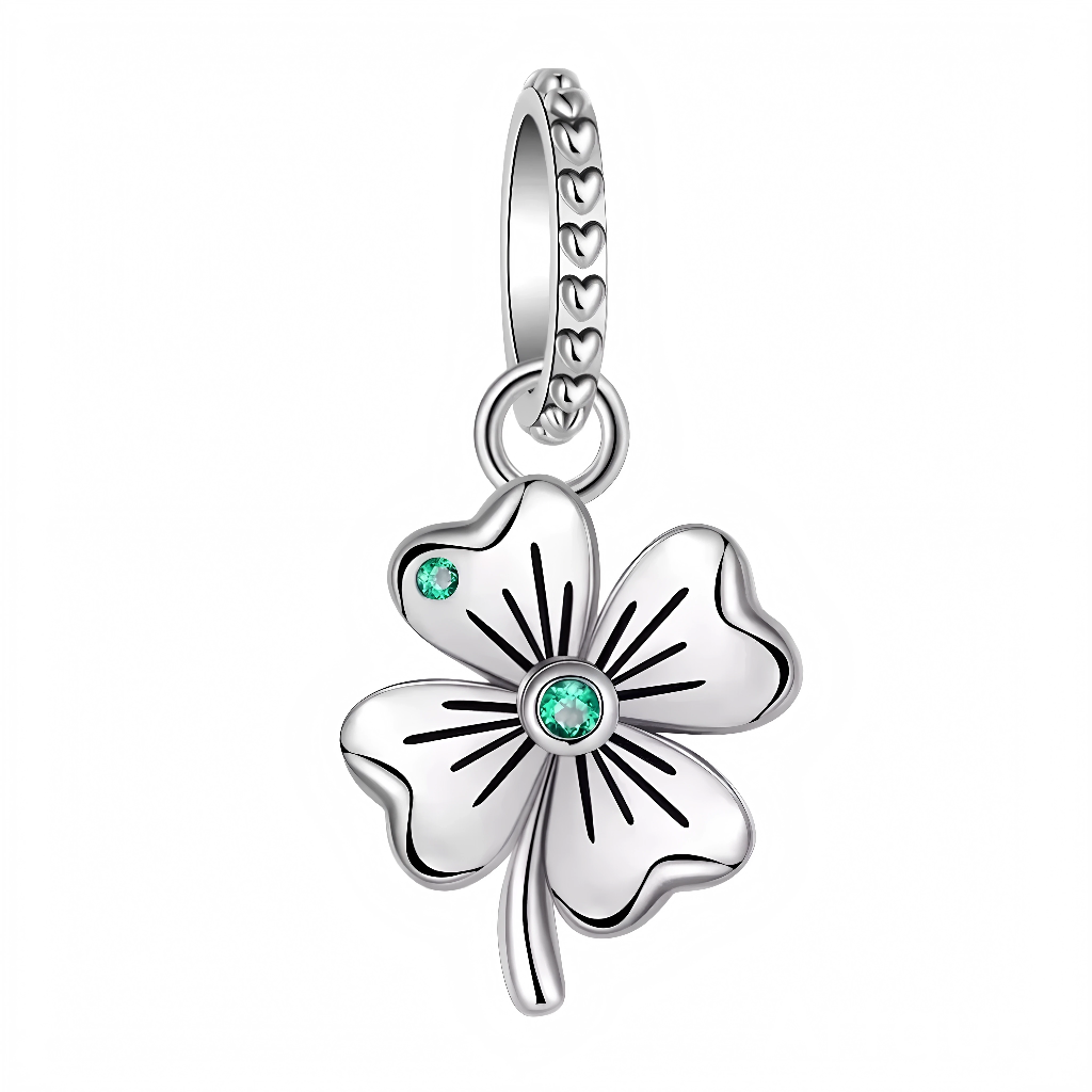 Ce charm met en scène un trèfle aux feuilles bombées et nervures gravées pour un relief élégant. Deux cristaux verts, l’un au centre et l’autre sur un pétale, apportent éclat et couleur, tandis que la bélière cerclée de cœurs souligne l’esprit porte‑bonheur. Parfait pour souhaiter réussite, protection et ondes positives.