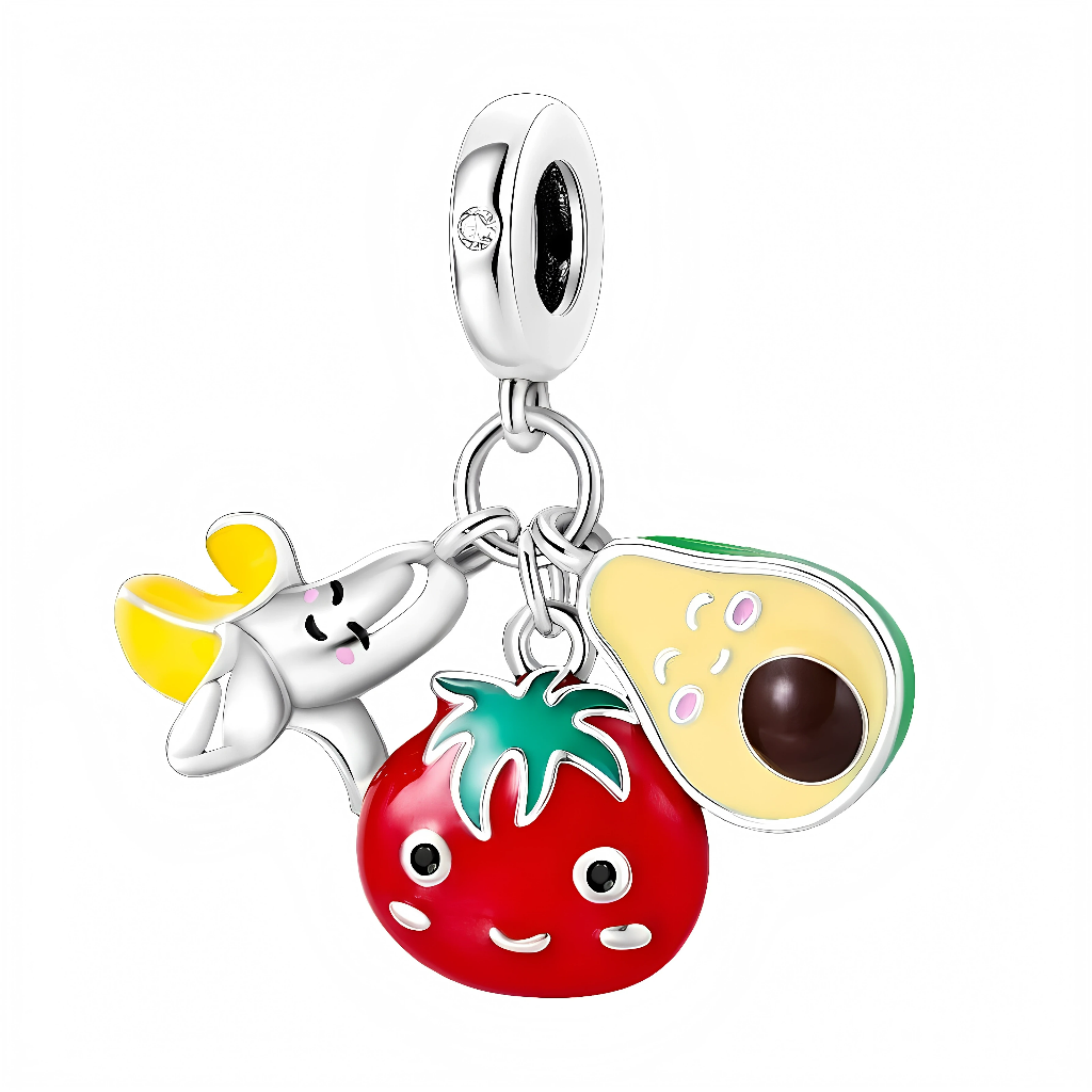 La bélière lisse en argent 925 est rehaussée d’un petit zircon clair, d’où pendent trois breloques mobiles : une banane pelée jaune, une tomate rouge ronde avec feuillage vert et un demi‑avocat crème et vert avec noyau brun, tous décorés de visages expressifs. Les émaux brillants et les contours argentés donnent un effet cartoon très ludique, idéal pour les fans de bijoux colorés ou de thématiques food.