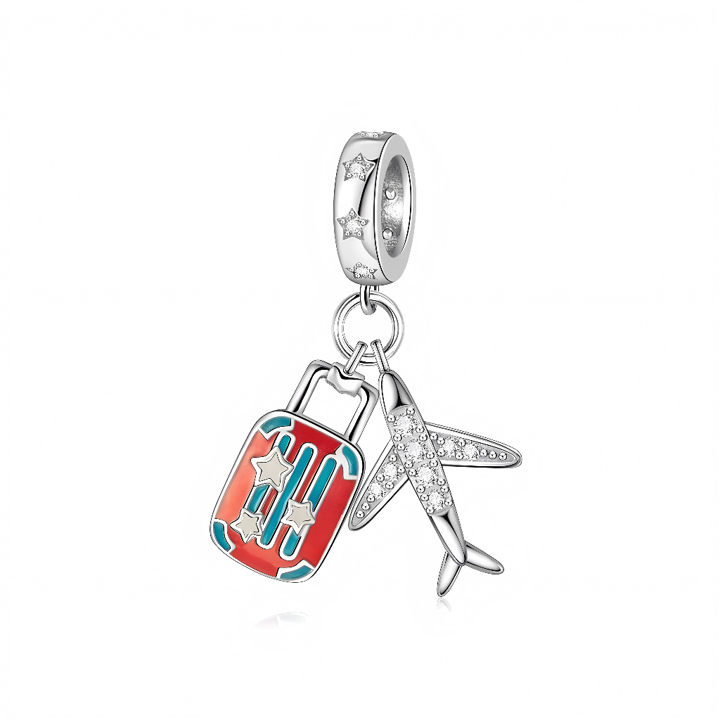 La bélière en argent 925 est ornée de petites étoiles gravées et serties, évoquant le ciel nocturne. Deux breloques mobiles y sont suspendues : une valise cabine rouge émaillée avec détails turquoise et étoiles argentées, et un avion élancé pavé de zircons clairs sur les ailes et le fuselage.