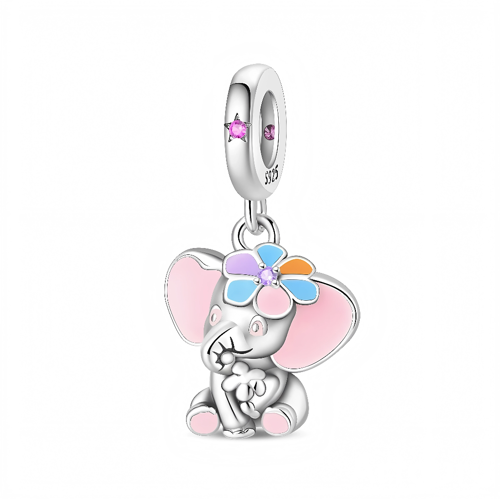 La bélière lisse est sertie de petites pierres roses, d’où descend l’éléphant au regard doux tenant une petite fleur entre ses pattes, ce qui renforce son côté tendre et protecteur. Les émaux bleu, orange, rose et lilas de la couronne florale créent une touche de couleur joyeuse idéale pour un thème enfant, maternité ou amour des animaux.jolilily+2