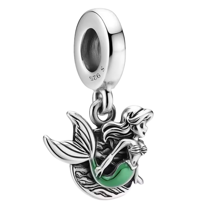 Ce charm pendentif en argent 925 présente Ariel la Petite Sirène devant un médaillon ovale aux vagues turquoise tourbillonnantes, silhouette élancée queue écailleuse émeraude, cheveux flottants, yeux émerveillés, coquillage sur poitrine. Il symbolise trésors marins secrets, rêves terrestres et magie océanique capturée.

Caractéristiques :

Matière : Argent 925 émail turquoise.
Design : Médaillon ovale ajouré, Ariel profil central dynamique, vagues gravées mobiles.
Dimensions : 2 cm hauteur, pendante fluide.