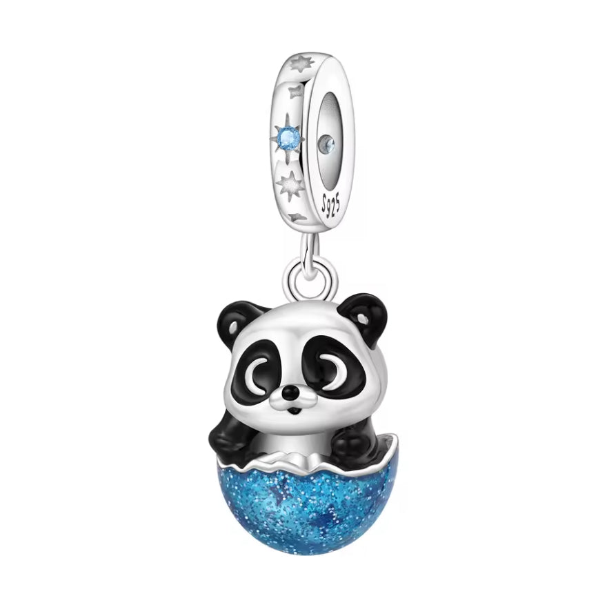 Ce charm adorable montre un petit panda aux grands yeux attendrissants, assis dans une coque bleue scintillante qui évoque un cocon protecteur ou une petite planète brillante. La partie inférieure est recouverte de résine ou d’émail bleu pailleté, offrant un magnifique contraste avec le noir et blanc du panda. La bélière S925 est décorée de motifs étoiles ajourées et d’une pierre bleue qui rappelle le ciel nocturne, donnant à l’ensemble une touche féerique. Idéal pour symboliser la douceur, la protection ou