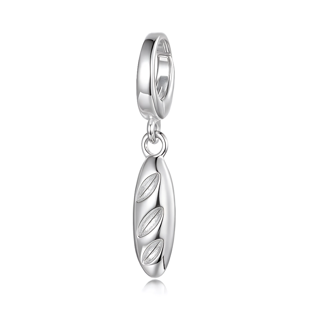 Ce charm pendentif reproduit une baguette française classique en argent sterling, avec sa forme oblongue allongée et ses trois entailles profondes typiques du pain de campagne croustillant. Les incisions en relief et la texture subtile évoquent la croûte dorée fraîchement sortie du four, symbole incontournable de la boulangerie parisienne. Suspendu à un anneau simple, il balance avec appétit au poignet, prêt pour une escapade gourmande virtuelle.