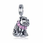 Ce charm pendentif capture un bouledogue français au visage plissé caractéristique, sculpté en argent sterling avec un pelage texturé et un air espiègle et attendrissant. Son collier rose vif clouté de strass blancs ajoute une touche rock et féminine, soulignant sa personnalité audacieuse et câline. Une patte levée et la queue enroulée complètent ce portrait fidèle et charmant du compagnon à quatre pattes.