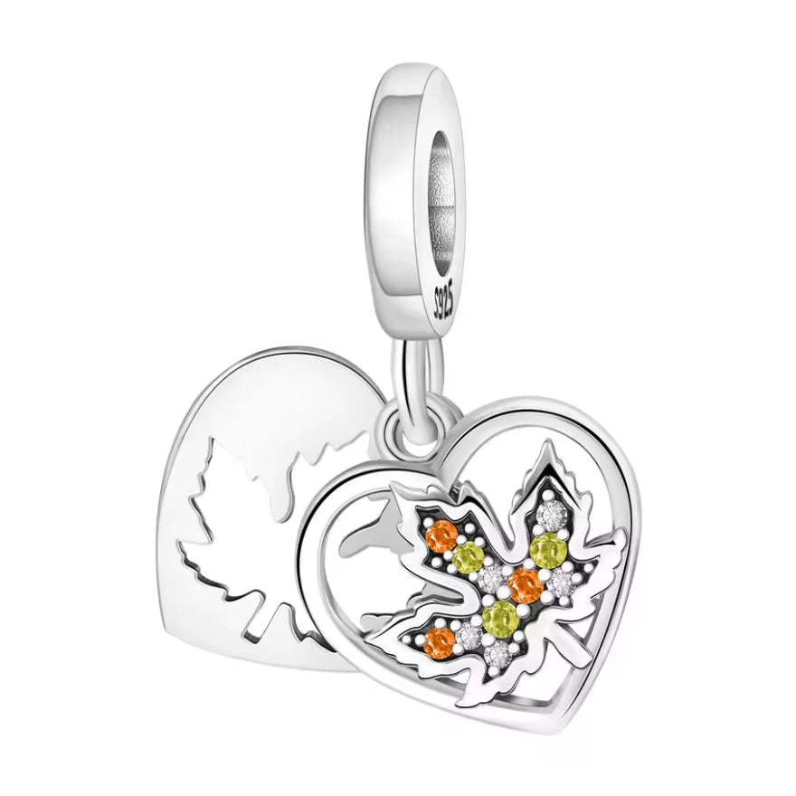 Ce charm se compose de deux cœurs mobiles: un cœur plein gravé d’une silhouette de feuille d’érable en arrière‑plan et, au premier plan, un cœur ajouré qui encadre une feuille pavée de petits cristaux scintillants aux couleurs des feuilles d’automne. La bélière lisse S925 assure une chute élégante sur le bracelet, tandis que les pierres orange, vert olive et blanches apportent lumière et relief. Une pièce idéale pour célébrer la saison des feuilles dorées ou pour un thème nature cosy.