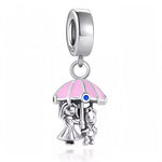 Ce charm sculpté en argent 925 capture mariée robe vaporeuse tenant parapluie rose rayé bleu, petit garçon souriant protégé dessous, accents roses tendres. Symbole intimité protection douceur sous averse amoureuse.

Caractéristiques

Matière : Argent 925 émail rose bleu brillant.
Design : Couple parapluie mobile, bélière ronde.
Compatibilité : Bracelets colliers thèmes amour famille.