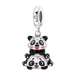 Ce charm plein de bonne humeur montre un panda allongé sur le dos, l’air surpris et amusé, tandis qu’un second panda lui grimpe dessus en riant, comme en plein jeu. Leurs joues rouges et leurs petites pattes détaillées apportent une touche de couleur et de dynamisme, faisant de ce bijou un symbole de complicité, d’amitié et de fous rires partagés. La bélière lisse S925 est discrètement ornée d’un strass clair en forme de cœur pour une note brillante et tendre.