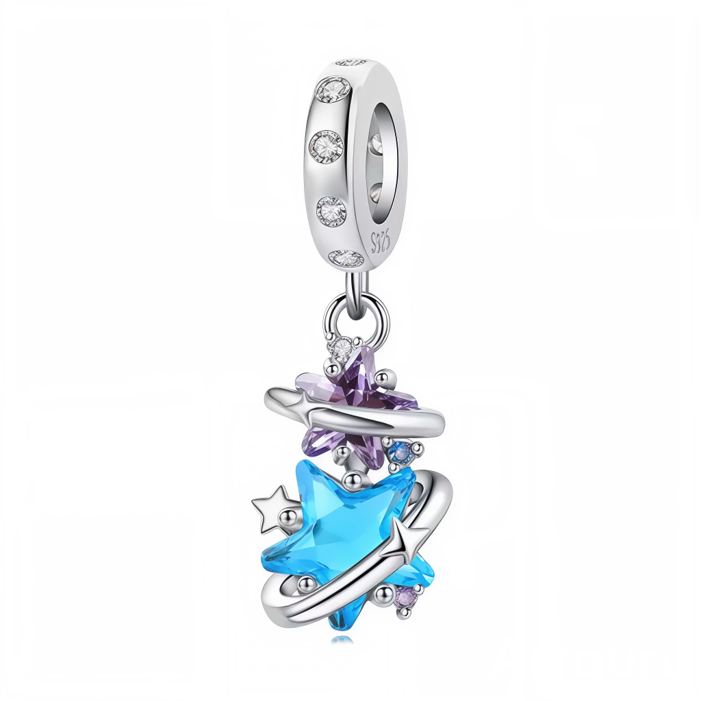 Ce charm pendentif capture l’essence d’une galaxie en mouvement, avec une étoile bleue facettée au centre d’anneaux argentés tourbillonnants pour un effet cosmique hypnotique. Des petites étoiles et cristaux violets et bleus flottent autour, comme une constellation scintillante dans l’espace infini, illuminée par des pierres cubiques qui captent la lumière à chaque geste. L’anneau supérieur, serti de pierres claires, permet au tout de danser délicatement au poignet, évoquant rêves d’exploration et mystère n