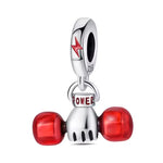 Ce charm pendentif motivant arbore une paire d’haltères stylisés en argent poli, avec des disques rouges brillants de chaque côté et l’inscription « POWER » en lettres rouges capitales sur la barre centrale. Une étoile rouge dynamique surmonte l’ensemble, symbolisant force explosive et détermination. L’anneau supérieur rond permet une fixation aisée sur les bracelets.