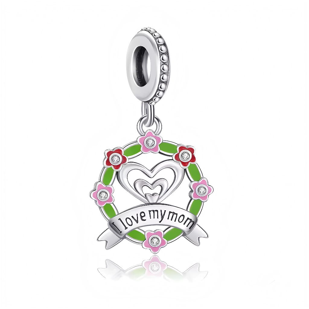 Ce charm pendentif&nbsp;affectueux&nbsp;déclare “I Love My Mom” sur un ruban vert enamel flottant sous un cœur double ajouré symbolisant amour maternel infini, entouré d’une couronne de fleurs multicolores (rose, blanc, vert) avec centres strass étincelants pour fraîcheur printanière. La structure ciselée en argent sterling poli ajoute délicatesse romantique, suspendue à un anneau lisse poinçonné « S925 ». Hypoallergénique et robuste, parfait pour Fête des Mères, cadeaux anniversaires ou bracelet sentimenta