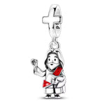 Charm pendentif représentant Jésus-Christ, avec une main levée en signe de bénédiction et tenant un livre, vêtu d’une robe avec un sash rouge. La bélière en forme de croix renforce le caractère religieux du bijou.

Caractéristiques :

- Matière : Argent 925.
- Design : Jésus-Christ avec livre et geste de bénédiction.
- Détail : Croix intégrée sur la partie supérieure.
- Couleur : Argent avec détails rouges.
- Style : Religieux, symbolique et élégant.
- Symbolique : Foi, bénédiction, protection et spirituali
