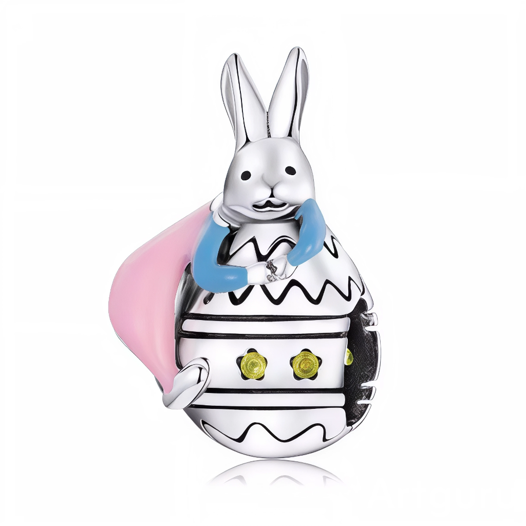 Ce charm pendentif dépeint un lapin blanc joyeux déguisé en œuf de Pâques, avec un corps ovale décoré de motifs noirs zébrés et de petites pierres jaunes comme des touches de soleil printanier. Vêtu d’une cape rose fluide et d’un foulard bleu vif, il pose d’un air malicieux, prêt à distribuer surprises et bonheur pascal. L’anneau supérieur pavé de zircons ajoute un éclat festif à ce personnage espiègle.