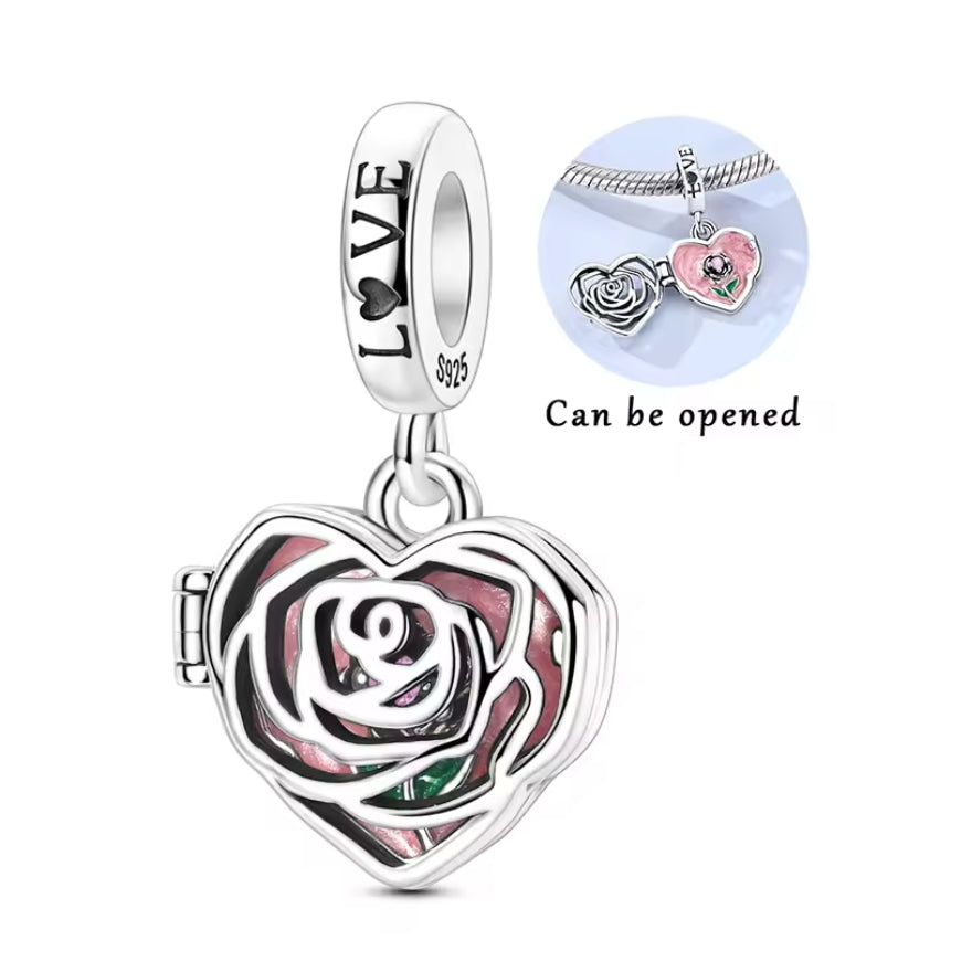 Ce charm pendentif romantique arbore un médaillon cœur en argent ciselé ajouré, s’ouvrant pour révéler une rose rose délicate au cœur vert feuillage. Les pétales texturés et contours élégants capturent l’essence passionnée et secrète de l’amour éternel. L’anneau supérieur rond offre une fixation fluide sur les bracelets.