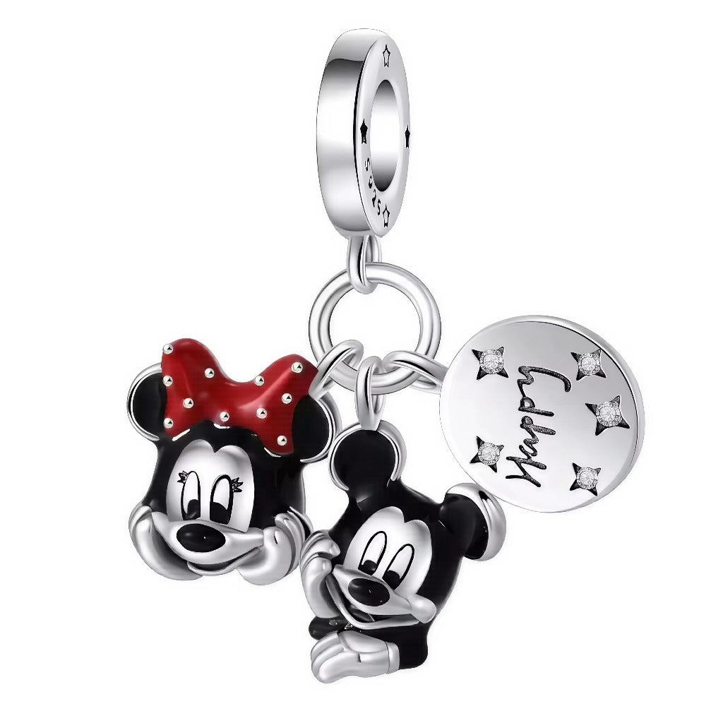 Ce charm pendentif célèbre la joie et la tendresse éternelles du couple emblématique Mickey et Minnie Mouse. Façonnés en argent fin, leurs visages expressifs et pleins de malice sont sublimés par des détails en émail noir et rouge, avec le célèbre nœud à pois de Minnie et un motif “Happy Day” gravé sur une médaille argentée. Les petites étoiles cristallines sur la médaille accentuent la magie du design et l’univers enchanté de Disney.