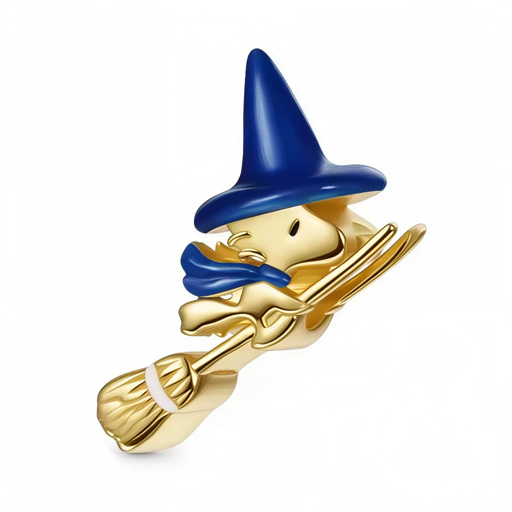 Ce charm capture Woodstock en plein vol, façon petit sorcier malicieux: silhouette plaquée or lumineuse, grand chapeau cône bleu nuit et écharpe flottante pour le mouvement. Le balai finement sculpté et la finition miroir offrent un rendu élégant et festif, parfait pour Halloween ou pour une touche fantastique toute l’année.