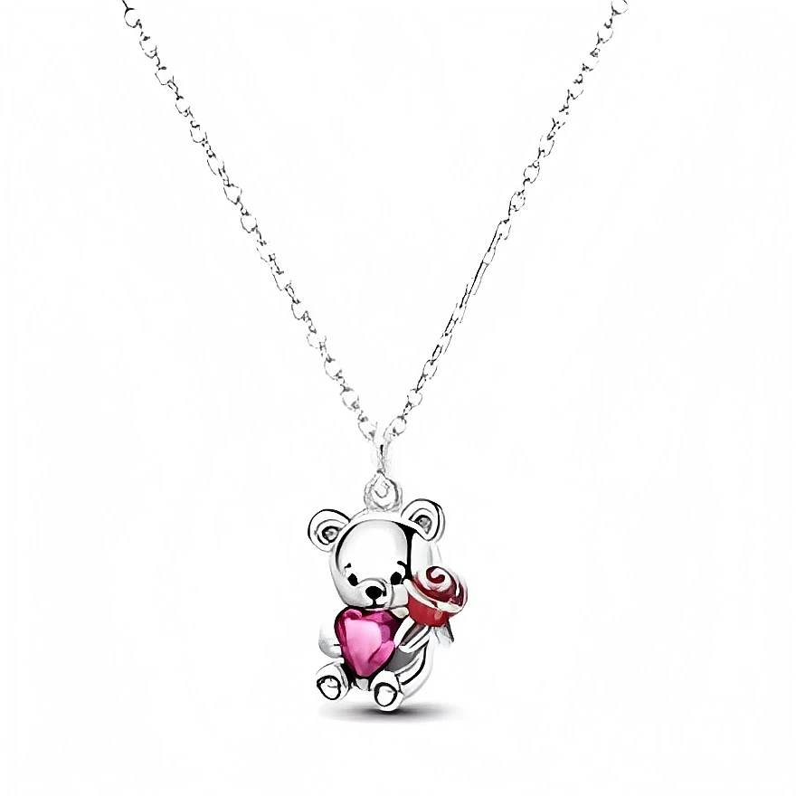 Ce collier en métal argenté présente un pendentif ourson adorable, au fini poli miroir, qui tient contre lui un cœur rose facetté façon cristal. Dans son autre patte, le petit ours serre une rose rouge stylisée, créant un duo romantique parfait pour symboliser la tendresse et l’affection.

Caractéristiques :

-Matière : Métal argenté avec cristal rose en forme de cœur et émail rouge pour la rose.
-Design : Ourson assis, détails gravés pour le museau et les pattes, cœur central et petite rose en relief.
-Col