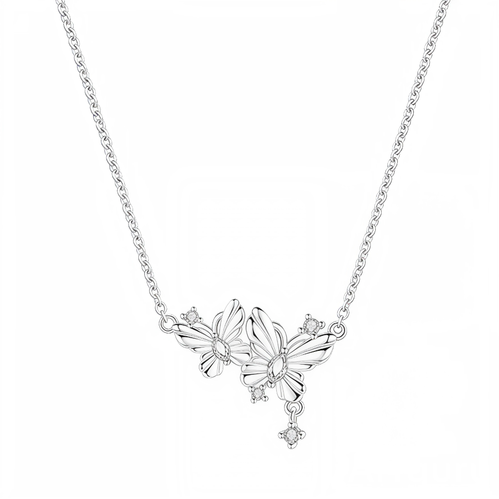 Ce collier en argent 925 met en scène deux papillons délicats en plein vol, placés côte à côte au centre de la chaîne, avec des ailes finement striées pour capter la lumière. Autour et sous les papillons, de petits cristaux ronds viennent former comme de minuscules fleurs ou étoiles scintillantes.

Caractéristiques :

-Matière : Argent 925/1000 (sterling silver) avec cristaux transparents.
-Design : Duo de papillons en relief, détaillés et féminins, agrémentés de petits brillants fixes et pendants pour un r
