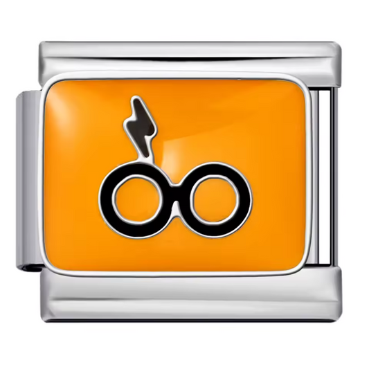 Ce charm italien stylisé représente les iconiques lunettes rondes de Harry Potter accompagnées de sa célèbre cicatrice en forme d’éclair, le tout mis en valeur sur un fond jaune lumineux. Confectionné en acier inoxydable argenté de haute qualité, il combine des détails précis et une finition éclatante pour séduire tous les fans de l’univers magique. Facile à fixer, il s’adapte parfaitement à nos bracelets composés de 17 maillons extensibles et réglables, adaptés à tous les poignets. Compatible avec tous nos