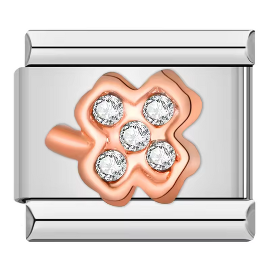 Ce charm italien en forme de trèfle à 4 feuilles associe une finition or rose élégante et une pierre blanche scintillante dans chaque feuille, le tout sur un fond argenté raffiné. Fabriqué en acier inoxydable de haute qualité, il allie robustesse et sophistication. Il se fixe facilement à nos bracelets composés de 17 maillons de charms, qui s’étendent et se contractent pour s’adapter parfaitement à votre poignet. Tous nos charms italiens sont entièrement compatibles, vous permettant de personnaliser votre b