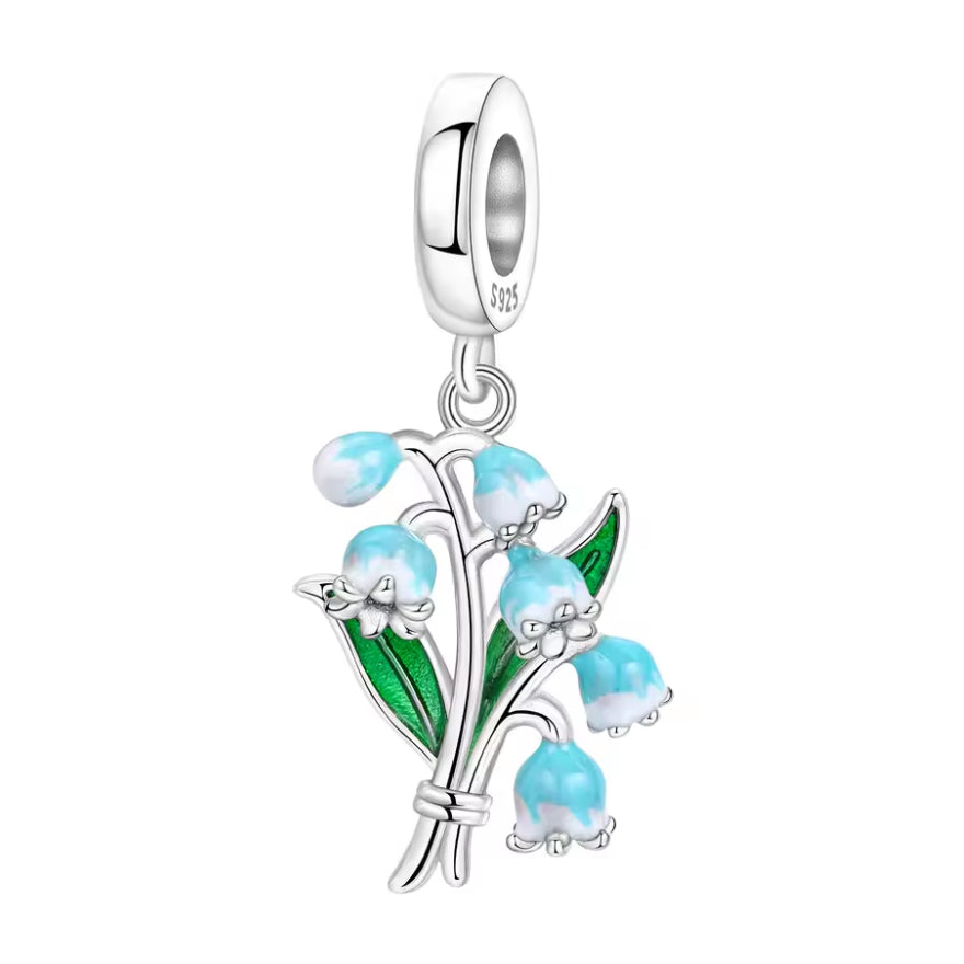 Ce charm met en scène un délicat brin de muguet noué à la base, avec plusieurs petites clochettes bombées émaillées d’un dégradé bleu ciel/blanc pour un effet frais et printanier. Les feuilles allongées vert brillant contrastent avec l’argent poli de la tige et de la bélière, offrant une pièce fine et poétique, idéale pour célébrer le printemps, la chance ou un nouveau départ.
