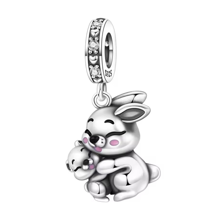 Ce charm attendrissant représente une maman lapin assise, les yeux fermés de bonheur, enlacant son petit lapereau contre elle. Leurs joues rosées et leurs expressions souriantes transmettent instantanément la douceur, la protection et l’amour maternel. La bélière S925 est délicatement ornée de petites pierres étincelantes et de motifs cœurs en relief, ce qui ajoute une touche précieuse à ce symbole de lien familial. Une pièce idéale pour célébrer une maman, une future maman ou simplement la tendresse entre 