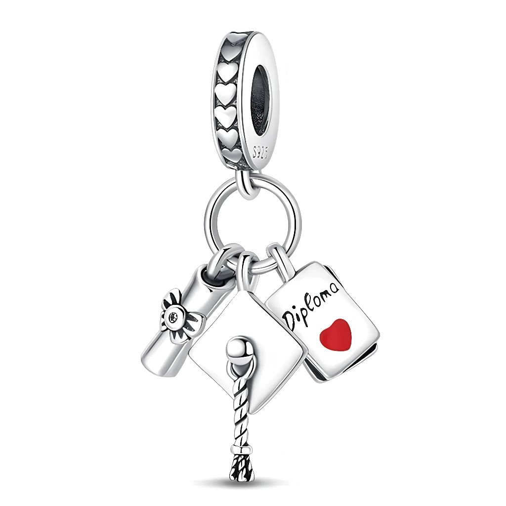 Ce charm pendentif en argent 925 est composé de trois breloques symboliques : un diplôme roulé décoré d’une petite fleur, un chapeau de graduation avec son pompon finement torsadé, et un livret gravé « Diploma » avec un cœur rouge en émail. Chaque élément célèbre la réussite scolaire et ajoute une touche personnelle au bijou. L’ensemble est suspendu à un anneau en argent orné de petits cœurs ajourés, ce qui apporte du relief et une finition élégante.