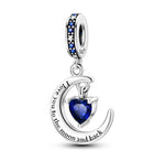 Ce charm romantique met en scène un croissant de lune argenté qui enlace un cœur bleu saphir en cristal, comme s’il le protégeait tendrement. La phrase “I love you to the moon and back” est gravée le long de la lune pour symboliser un amour infini, tandis que la bélière S925 est sertie de zircons bleus et blancs rappelant un ciel étoilé. C’est un bijou parfait à offrir pour déclarer son amour ou rappeler chaque jour à quelqu’un combien il compte.