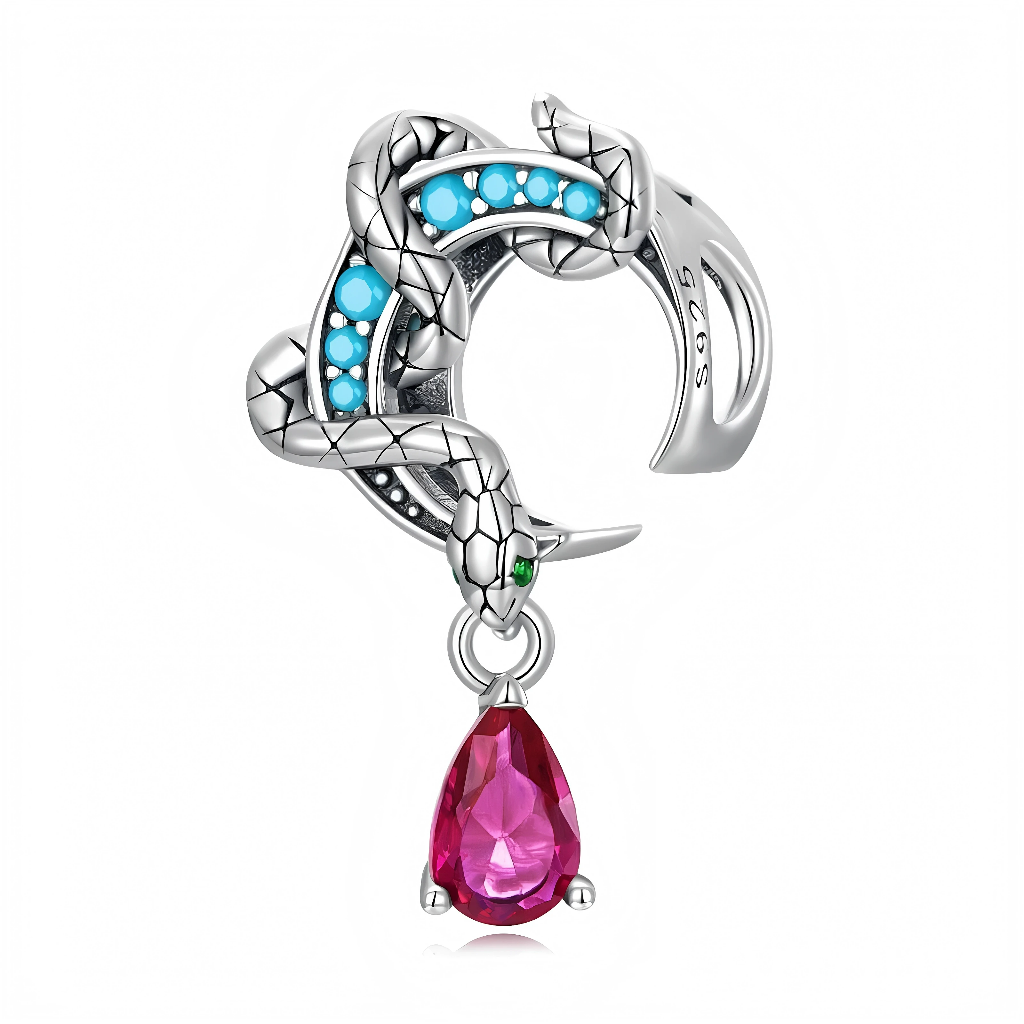 Ce charm en argent 925 met en scène un serpent gravé d’écailles qui s’enroule autour d’un croissant de lune, dont l’intérieur est rehaussé de petites pierres turquoise pour un contraste saisissant. À l’extrémité, une goutte facettée rose façon rubis est suspendue, tandis qu’un minuscule cristal vert illumine l’œil du serpent pour une touche encore plus mystérieuse.pangamajewelry+1