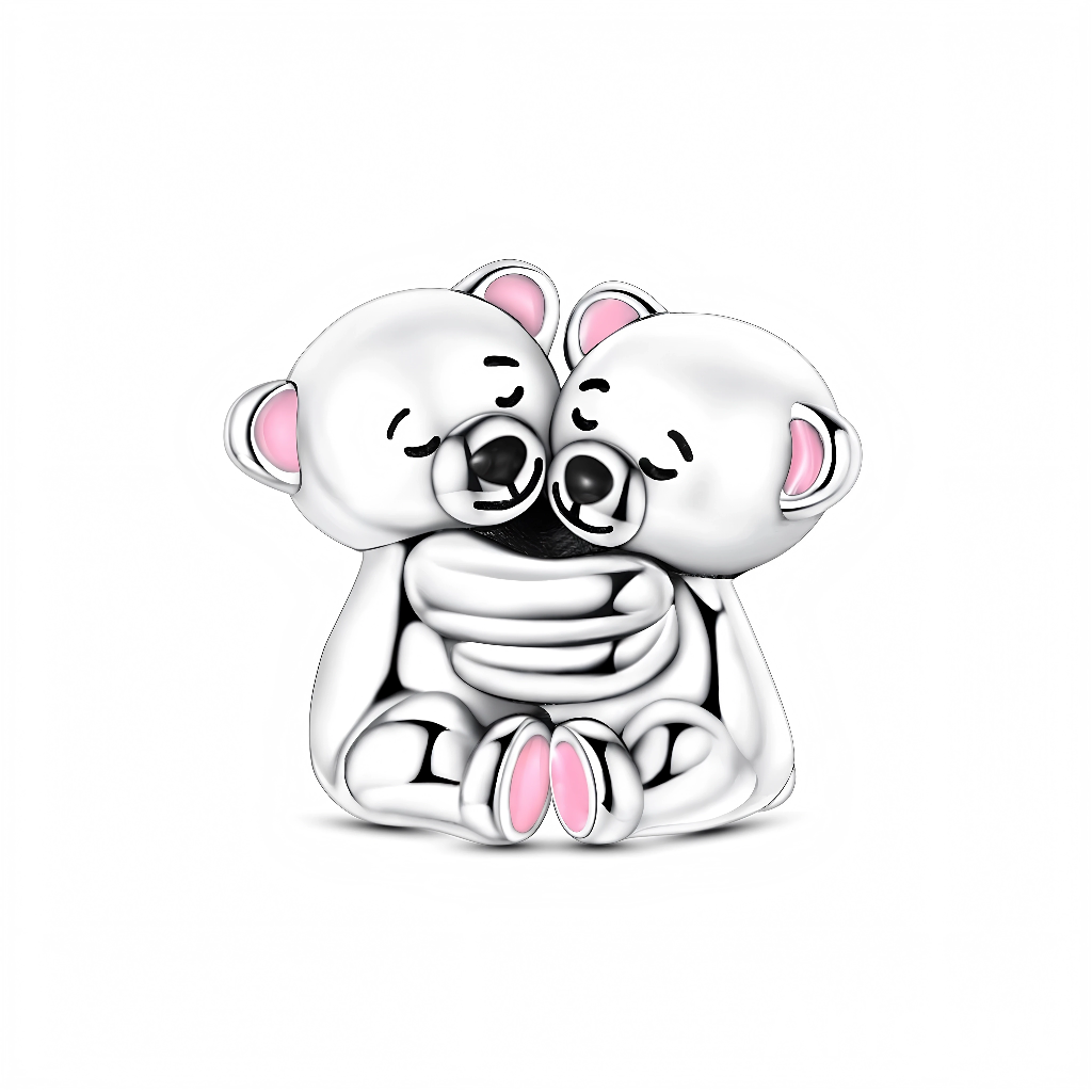 Ce charm représente deux petits ours assis, serrés l’un contre l’autre dans une étreinte tendre, les yeux fermés et les museaux touchés. Les détails d’émail rose dans les oreilles et sous les pattes apportent une note douce et enfantine qui renforce le côté réconfortant du bijou.